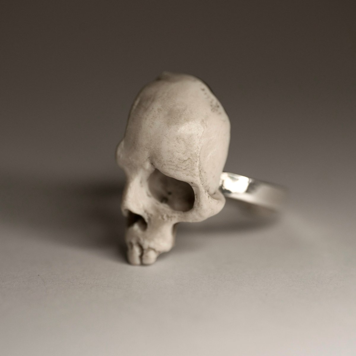 Skull Fragment ring on a grey background, focus on the skull part, its texture and details
