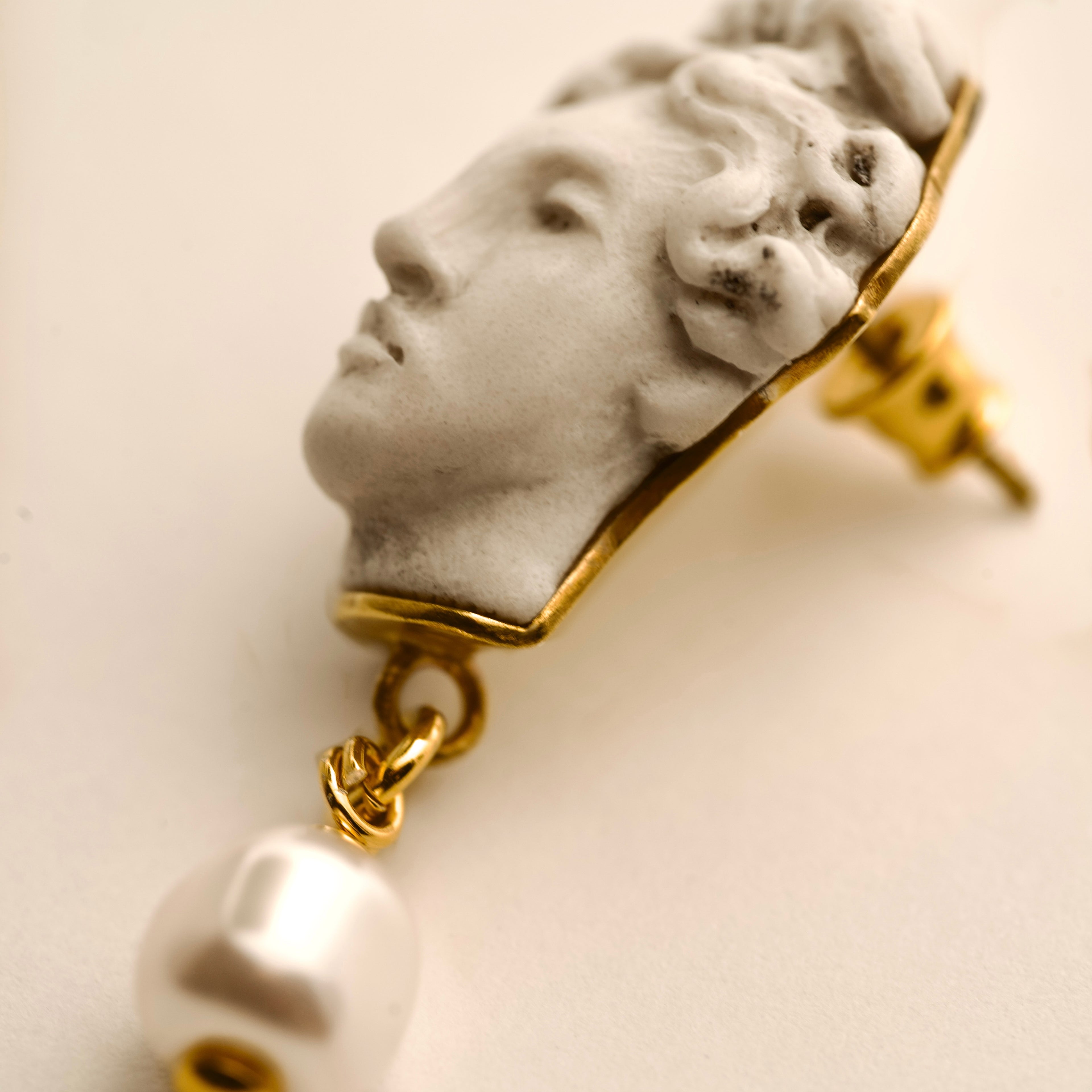 Aphrodite earring - boho statement earrings with classical head design and gold accents on a beige background