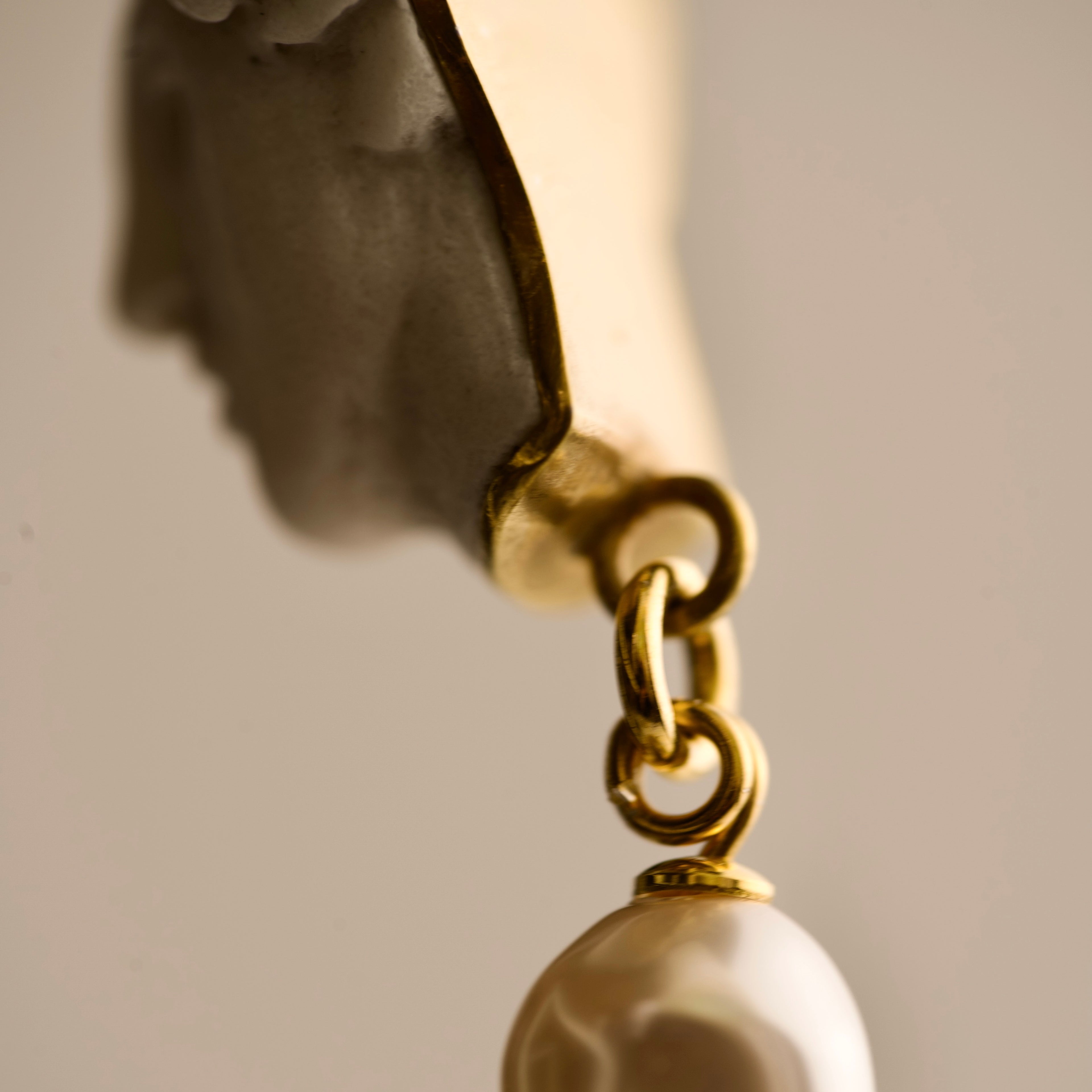 Close-up of Aphrodite earring showing gold-plated sterling silver holder with pearl drop, Greek mythology goddess jewelry