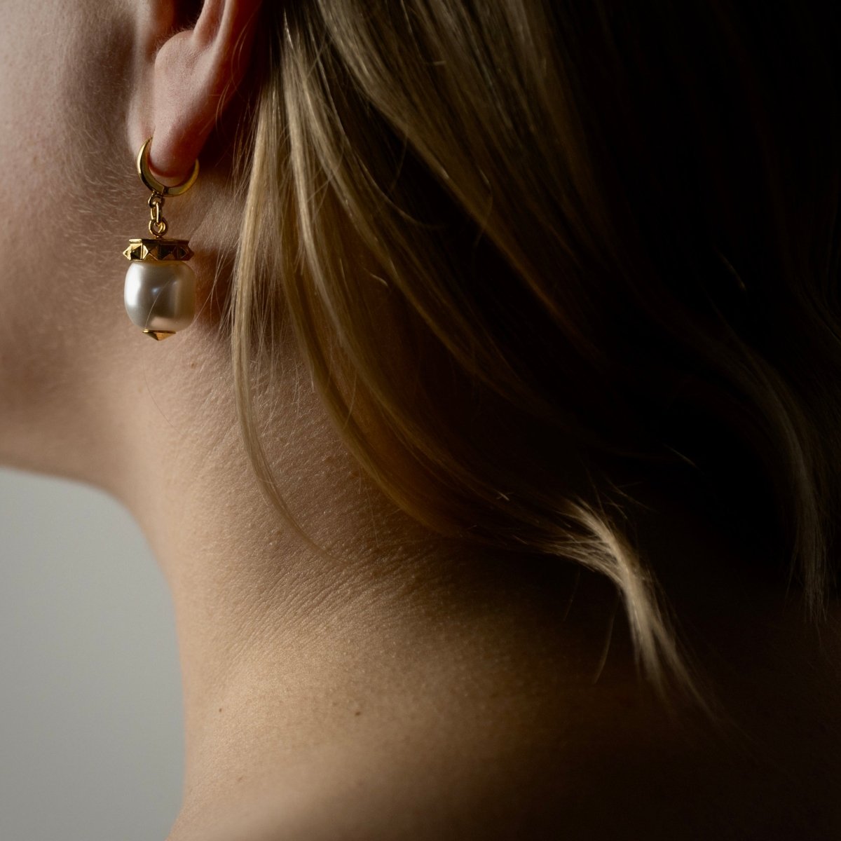 Female model with long hair wearing Baroque pearl earring, Mediterranean-inspired pearl jewelry lifestyle shot