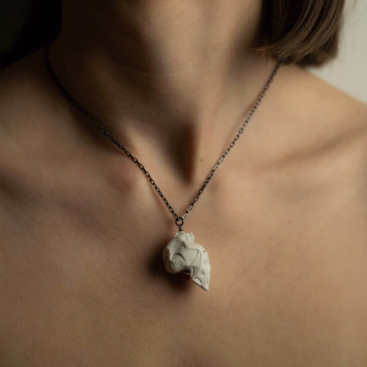 Skull & Bat pendant - white variant - on a female model, close up
