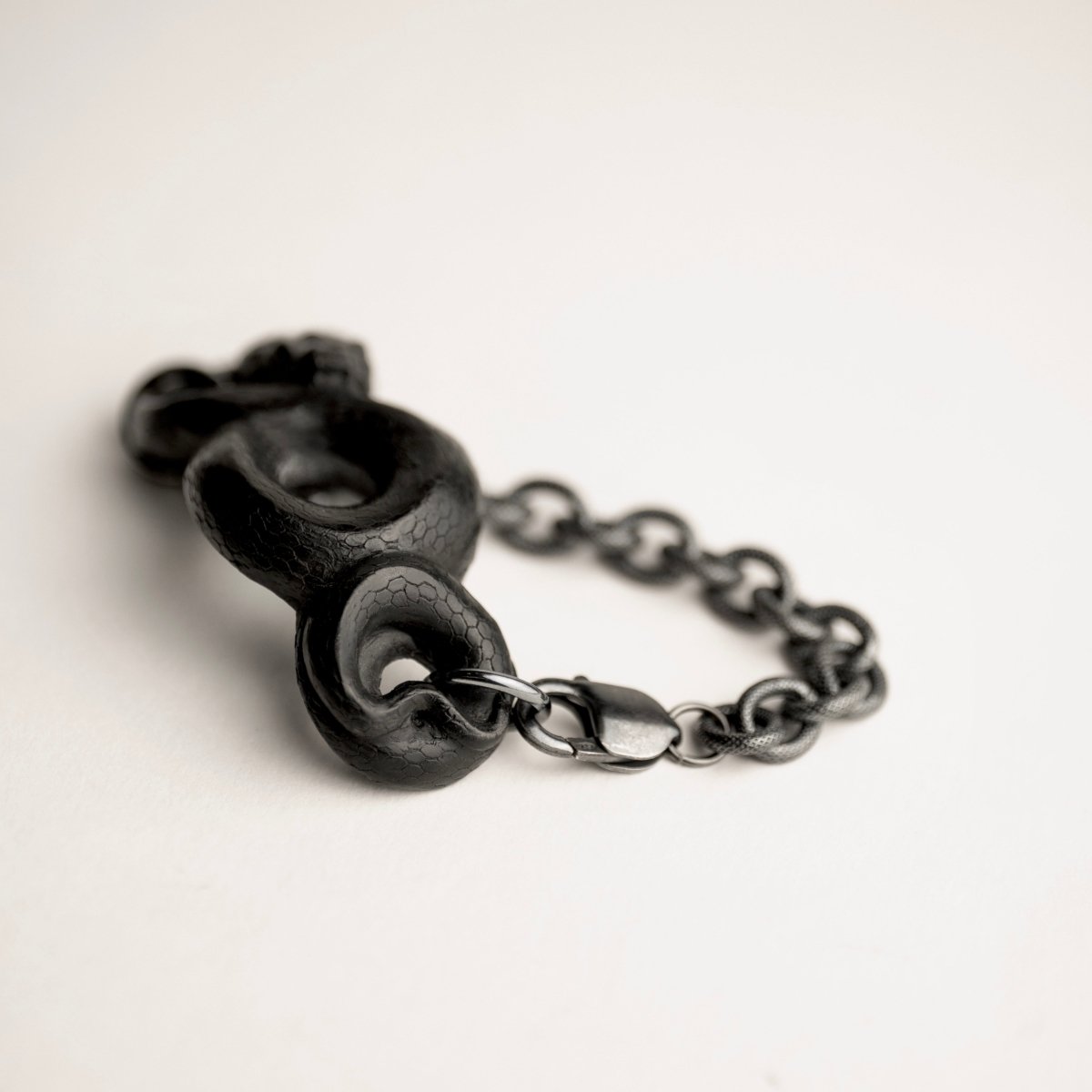 Black Snake bracelet on a white surface with lobster lock visible