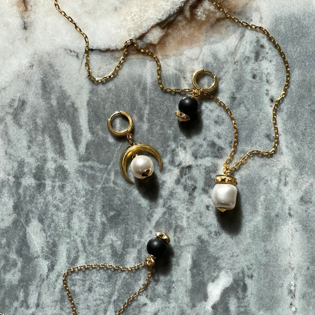 Blueberry earring, Moon earring and  Blueberry pendant by Macabre Gadgets on a marble surface