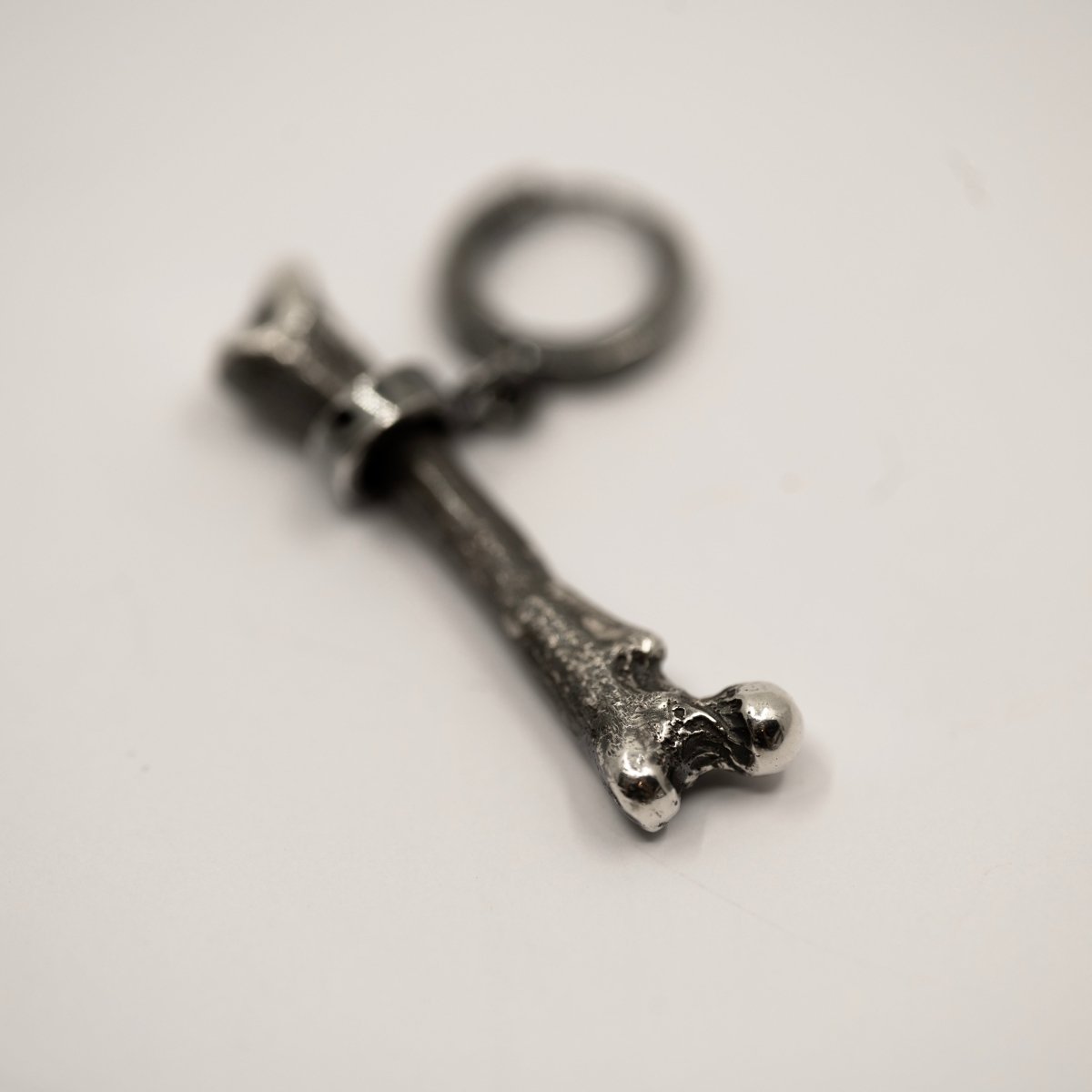 Silver Bone earring placed on the white surface 