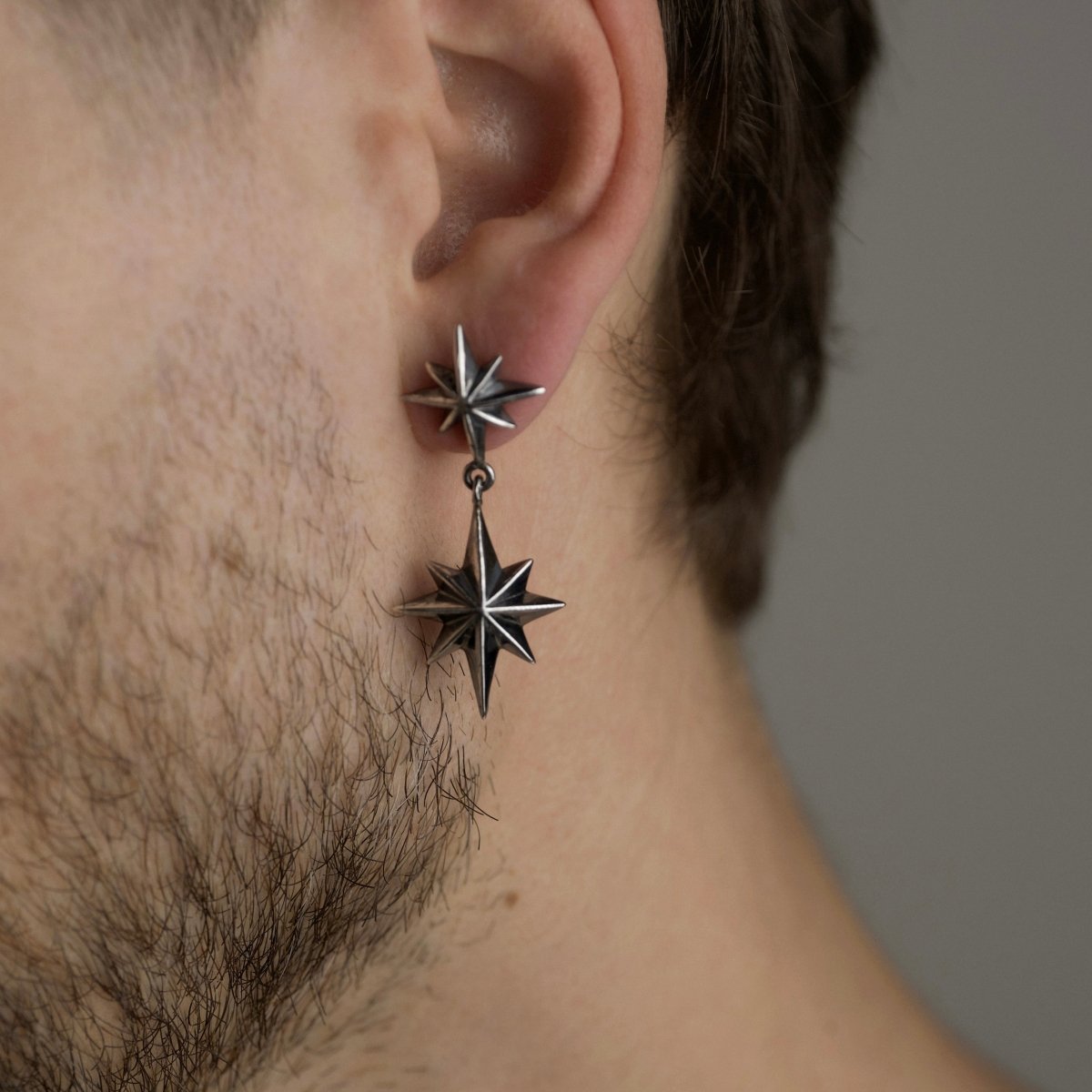 Bearded male model wearing Castor & Pollux earring by Macabre Gadgets, celestial twin stars jewelry lifestyle photography
