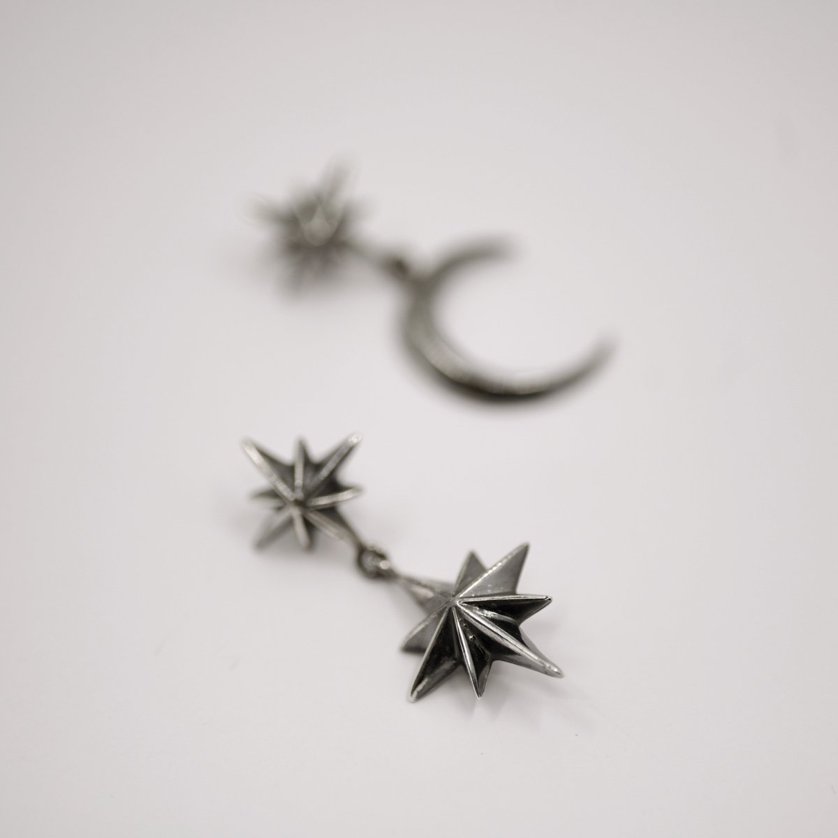 Castor & Pollux earring on white surface showing detailed twin stars design