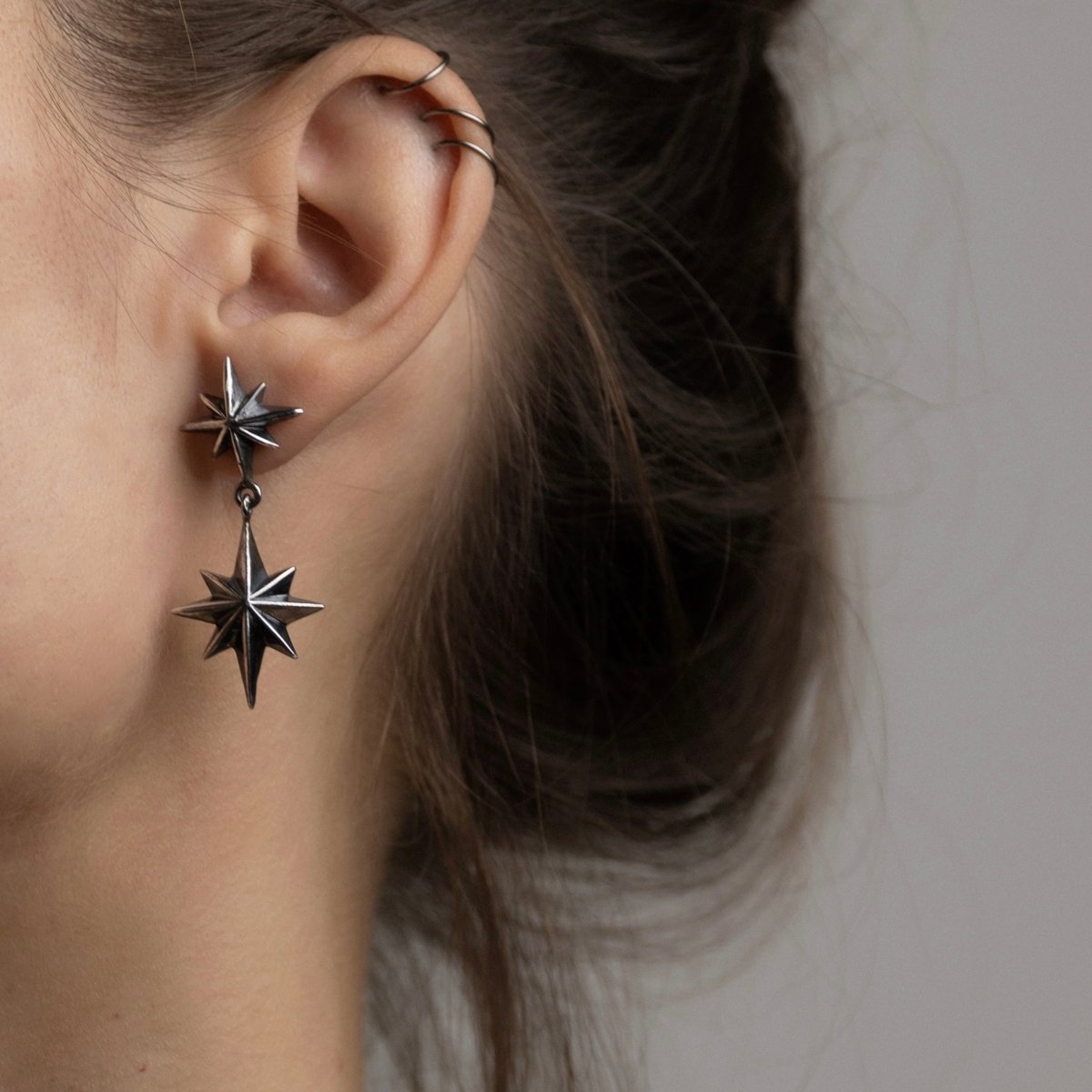 Female model wearing Castor & Pollux earring silver variant, handcrafted celestial sterling silver jewelry