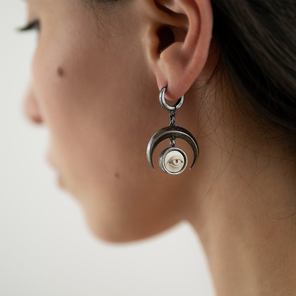 Female model wearing Crescent Oracle earring with sterling silver crescent moon and eye design, witchy jewelry lifestyle shot