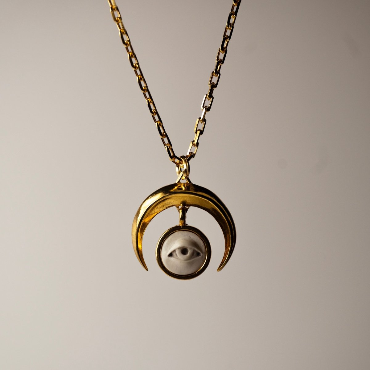 Crescent Oracle pendant - gold variant - front view, both moon and eye charms are visible