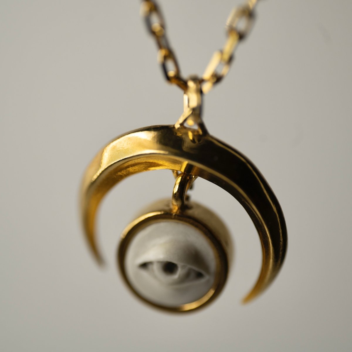 Crescent Oracle pendant - gold variant - close-up of the moon and the eye charms
