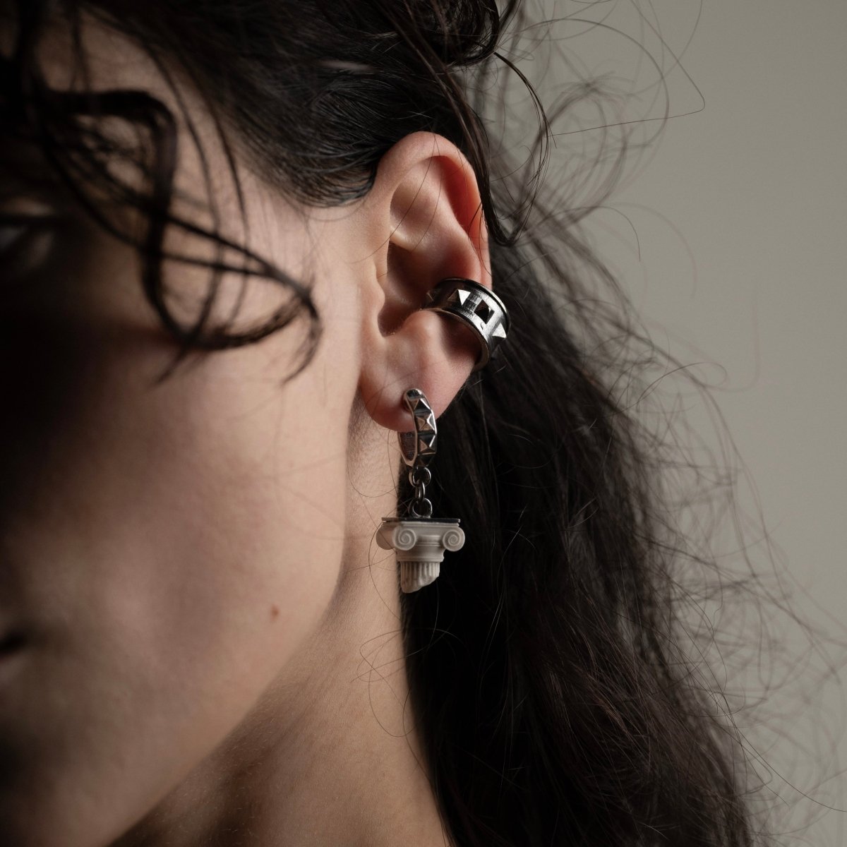 Female model with long dark hair wearing Ionic earring, Greek architecture jewelry lifestyle shot