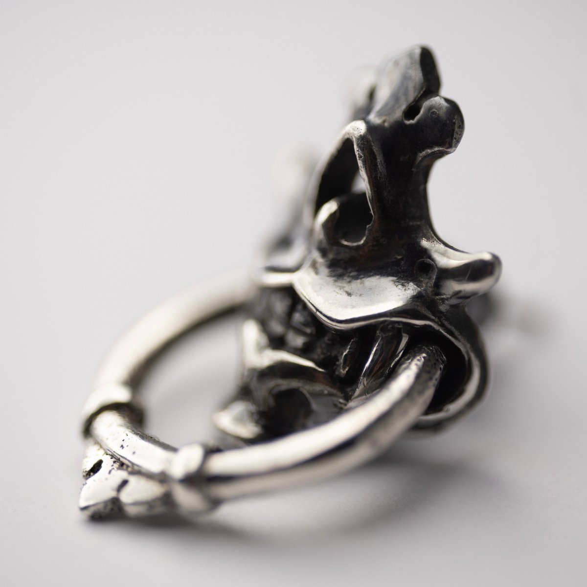 Silver Mask earring close up from the side
