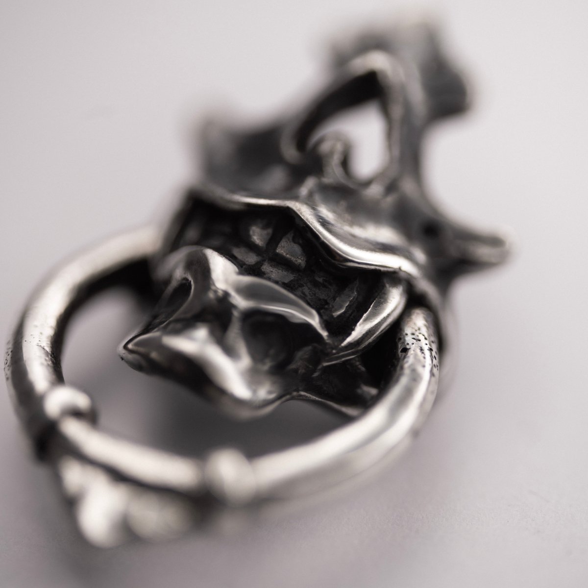 Silver Mask earring - close up on a ring and fangs details