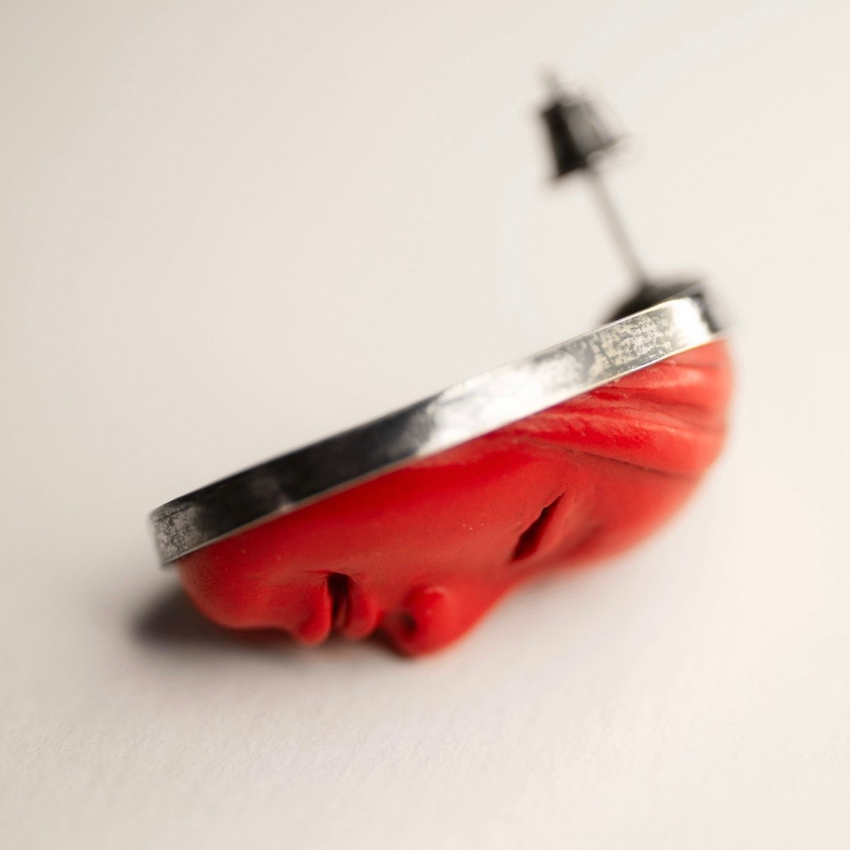 Mask earrings - red variant - close up, focus on face details and silver bezel holder