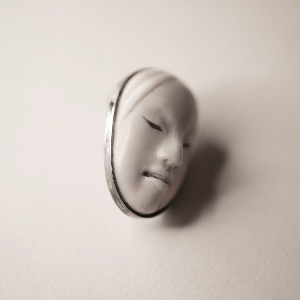 Mask earrings - white variant - close up, focus on serene face expression of the mask