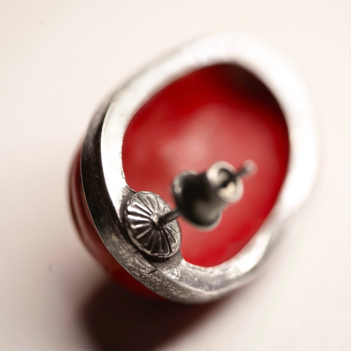 Mask earrings - close up on a red interior of the mask and elaborate decorated stud lock, secrets only wearer will know