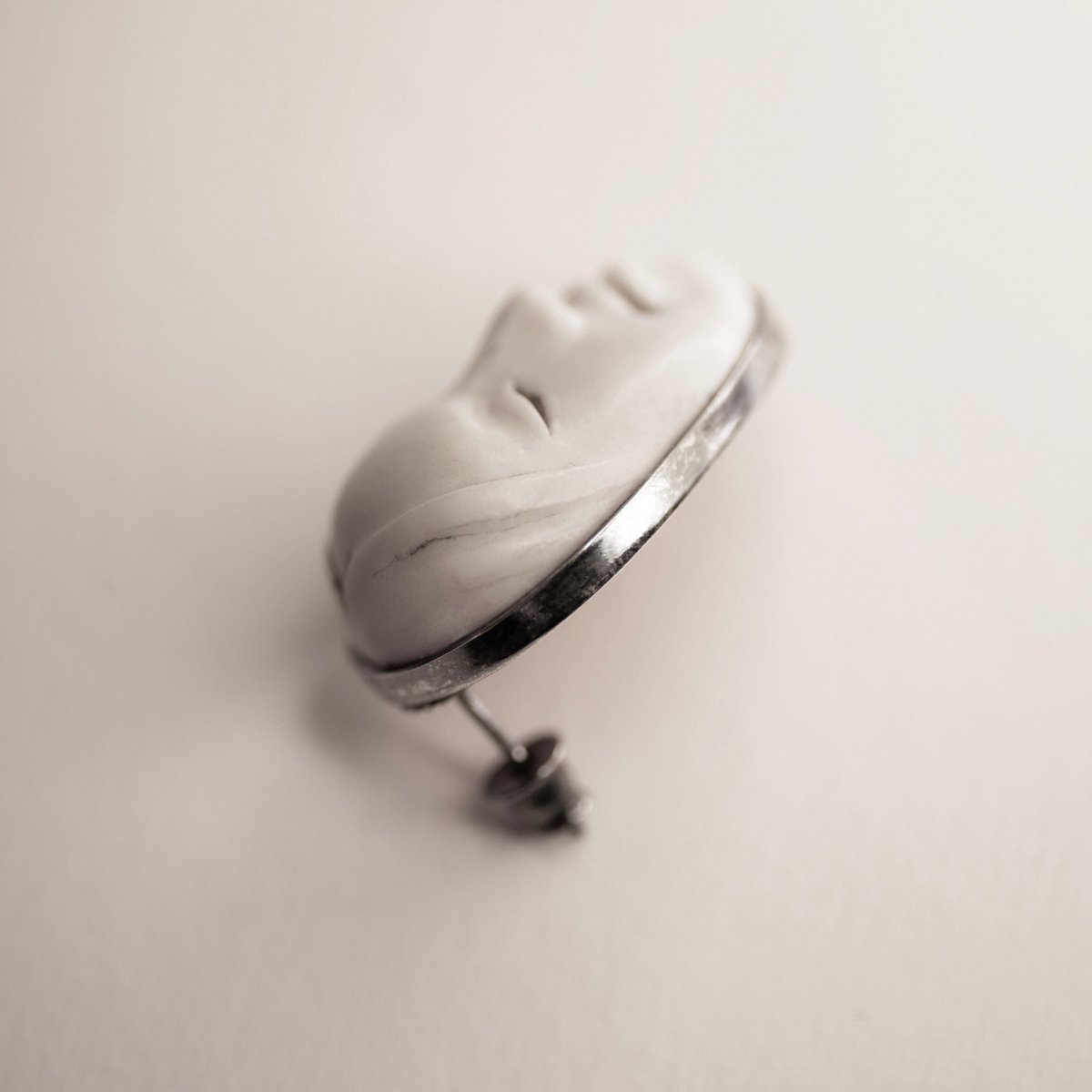 Mask earrings - white variant on a white surface, side view