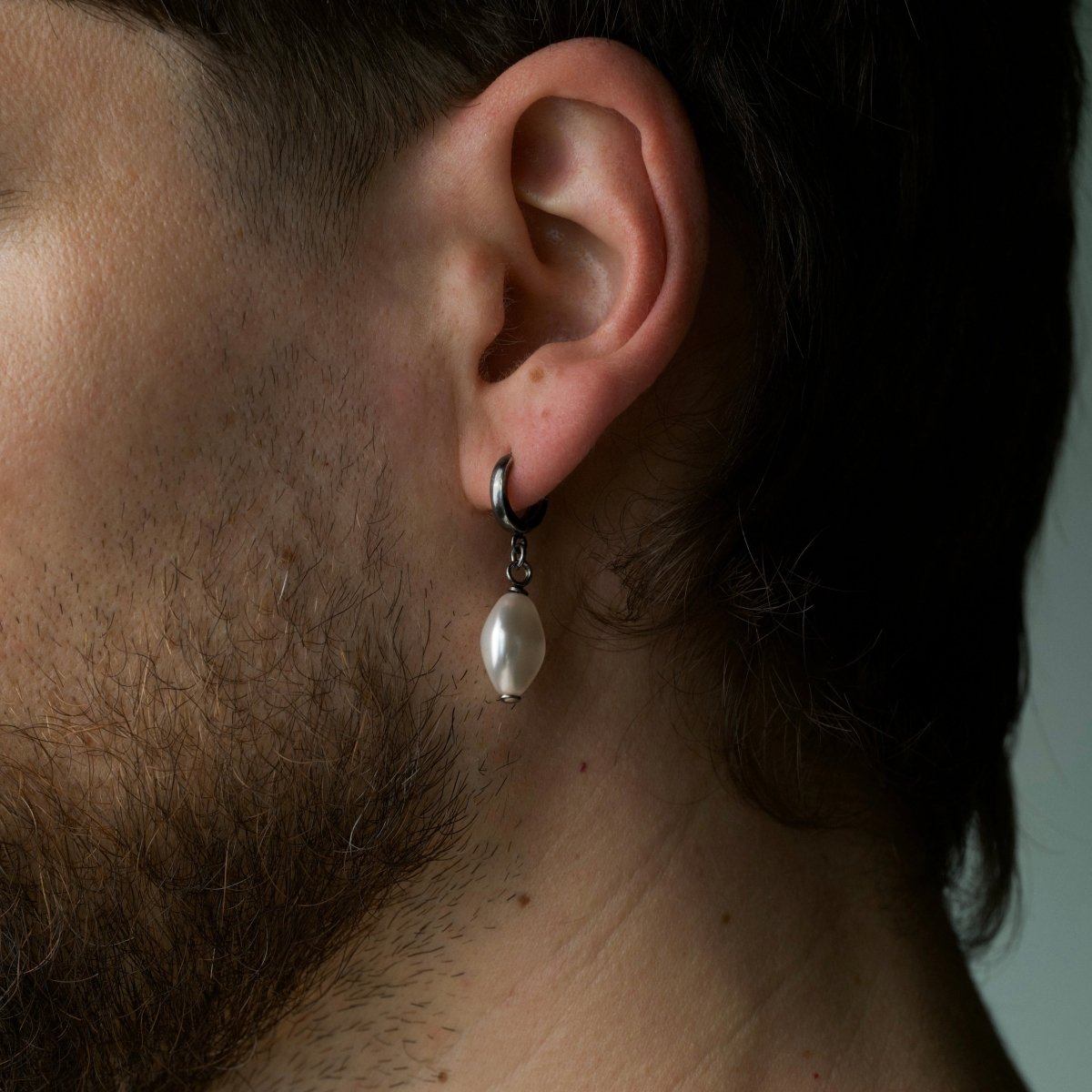 Male model wearing Pearl Coin earring close-up, lifestyle photography