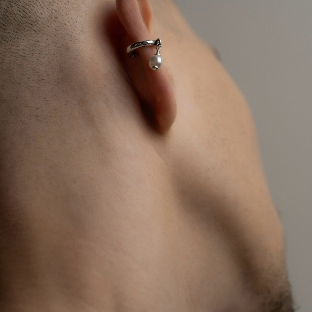 Male model wearing Pearl ear cuff close-up, no piercing required sterling silver jewelry lifestyle shot