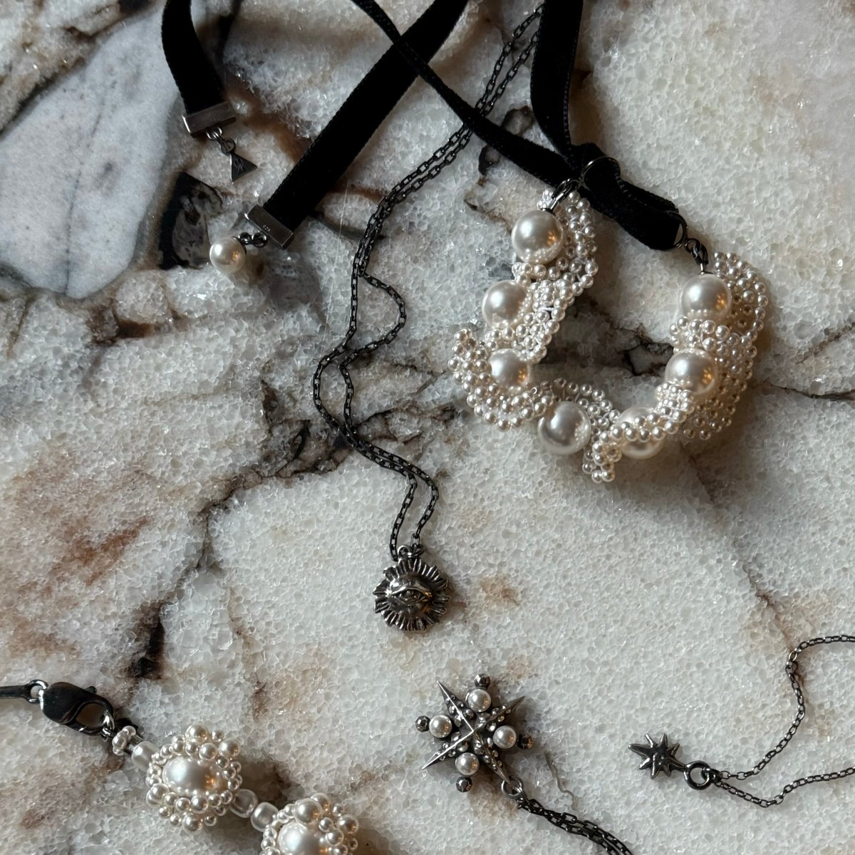 Pearl Lace bracelet along with other jewelry placed on marble surface