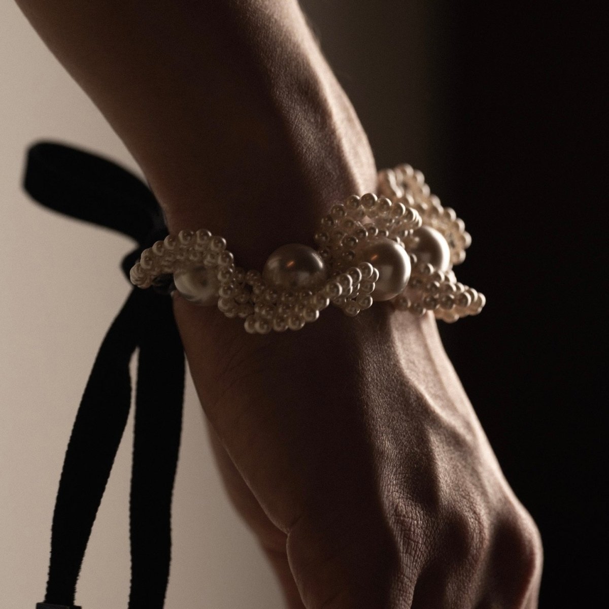 Pearl Lace bracelet on a wrist - black ribbon visible