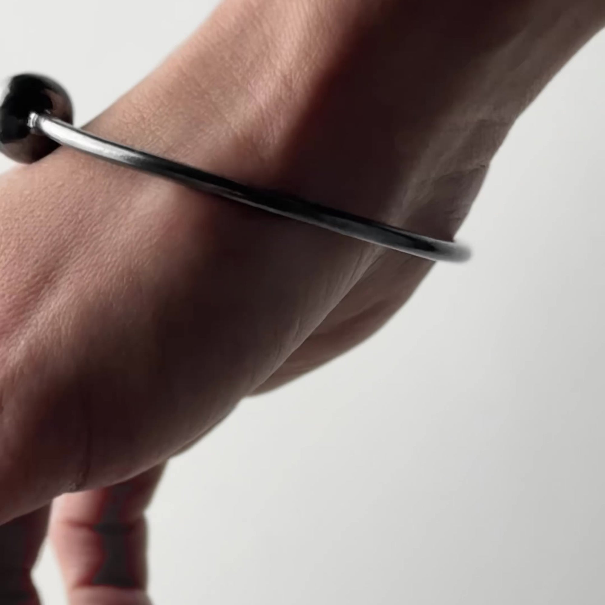 Video with a Pearl Cuff bracelet set on wrist with brand logo in the end