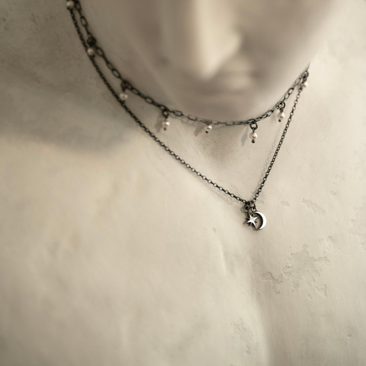 Selene Moon pendant and Ancient Pearl necklace styled on the neck of a marble sculpture