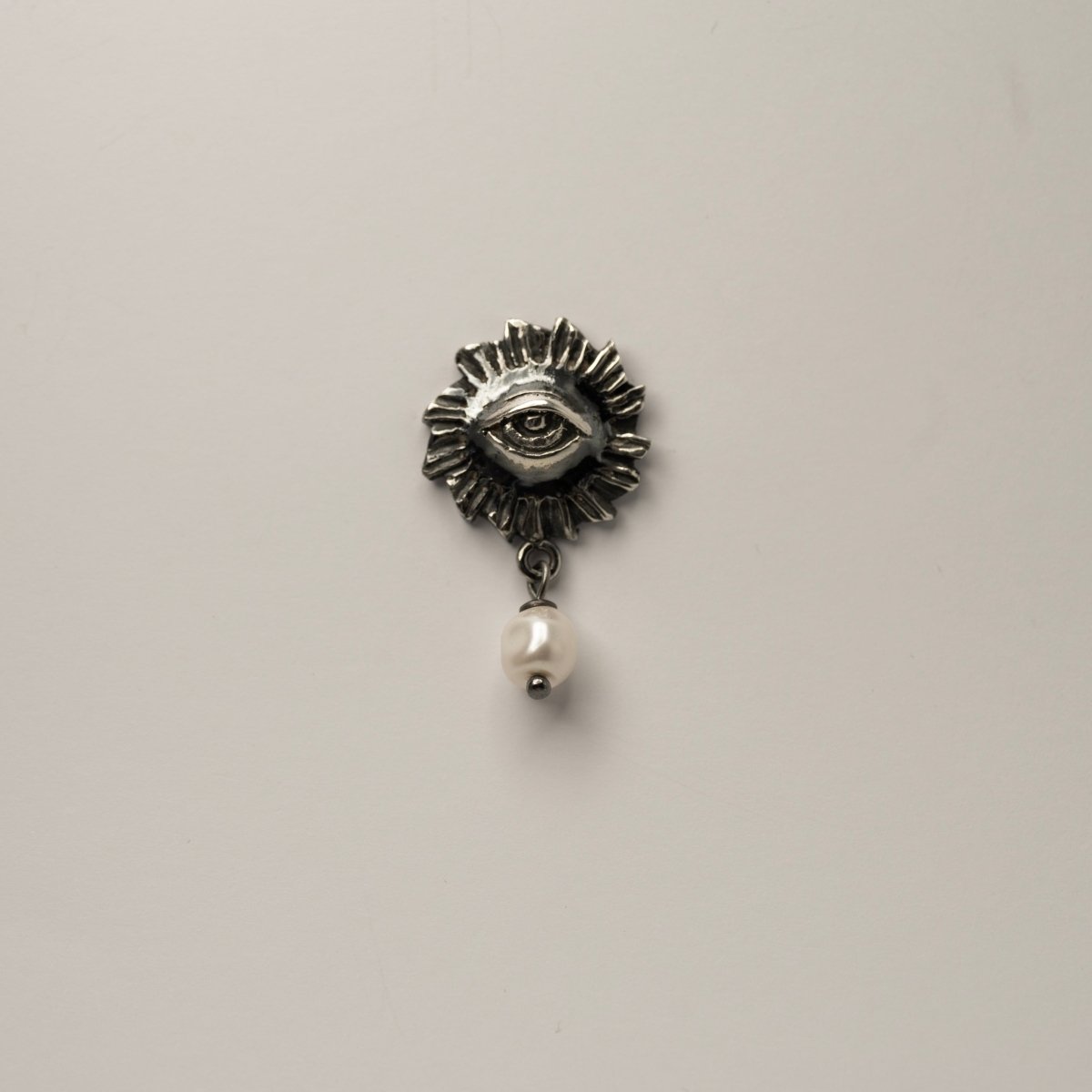 Sirius pearl earring with sterling silver eye design and mini pearl on neutral background, gothic mystical jewelry