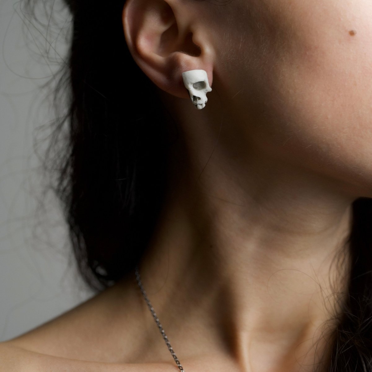 Skull Fragment earring on female model, demonstrating general fit and dimensions of the skull earring