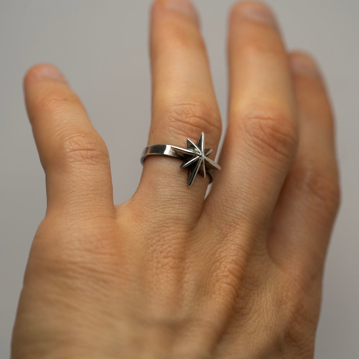 Star ring on a model's hand, focus on polished ring surface