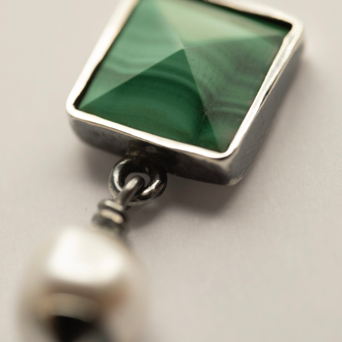 Malachite Studs earrings close-up showing pyramid-shaped malachite stone in sterling silver bezel setting