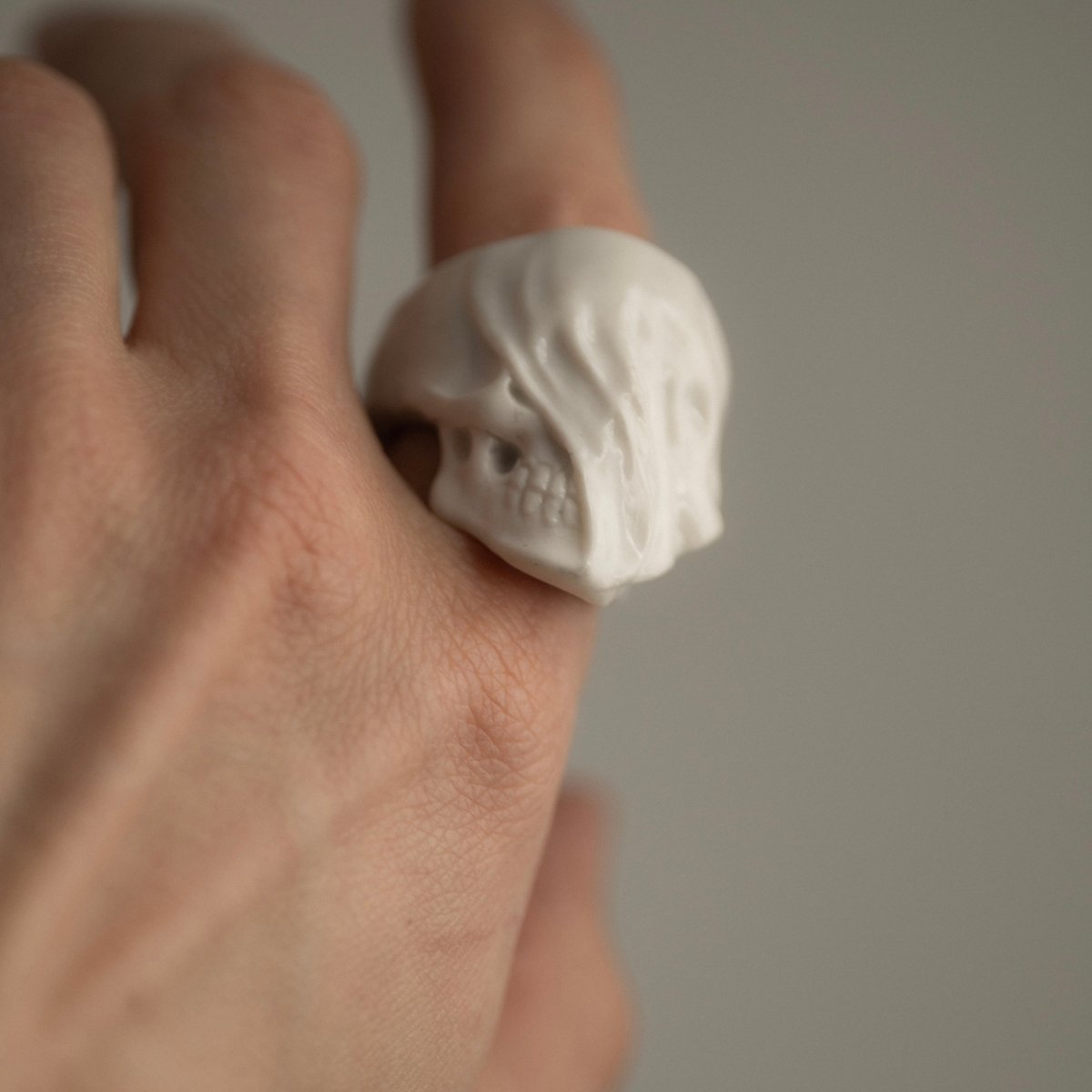 Veiled Skull ring - on a model's hand, index finger, close up