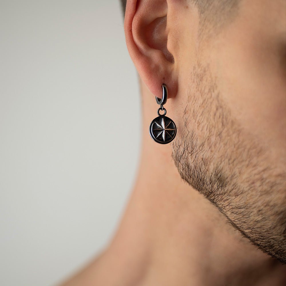 Male model wearing Aster earring - oxidised silver coin earring on hoop with star and moon design