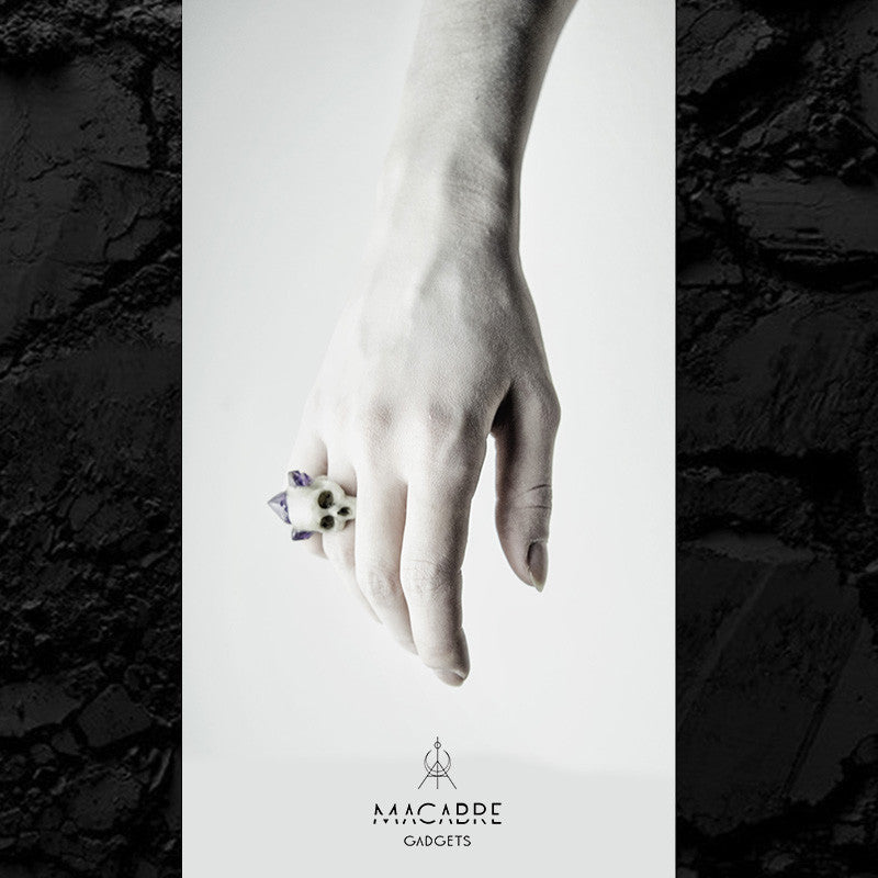 Bifacial Skull Ring on a model's hand, with logo of Macabre Gadgets, page from a look-book