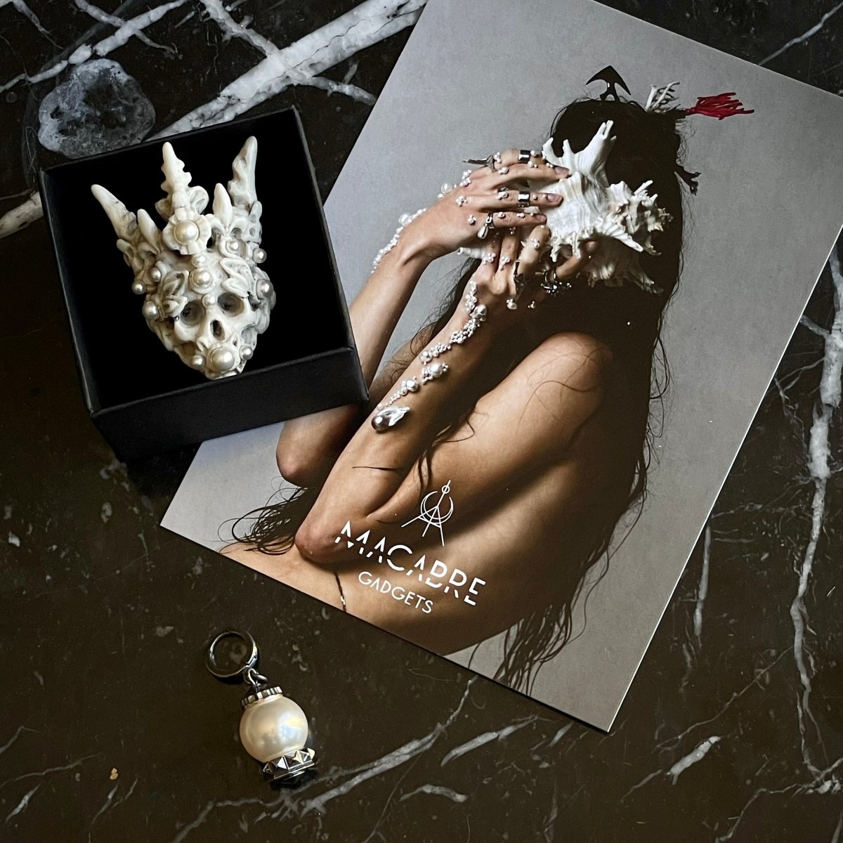 Coral Crown Skull ring in a jewelry box on black marble surface