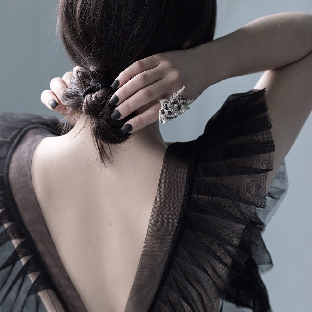 Female model in black evening gown wearing Coral Crown Skull ring - skull ring styling shot