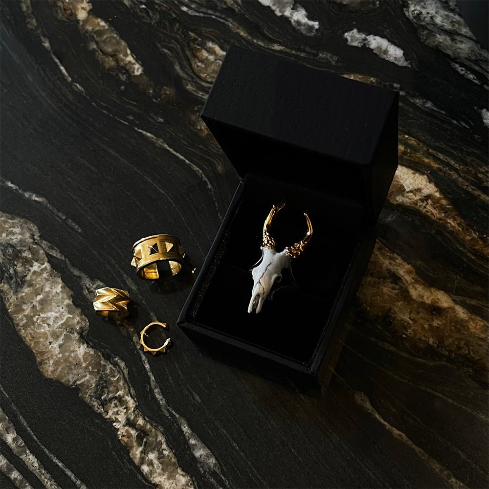 Doe ring placed in a jewelry box on a dark marble surface along with other jewelry by Macabre Gadgets