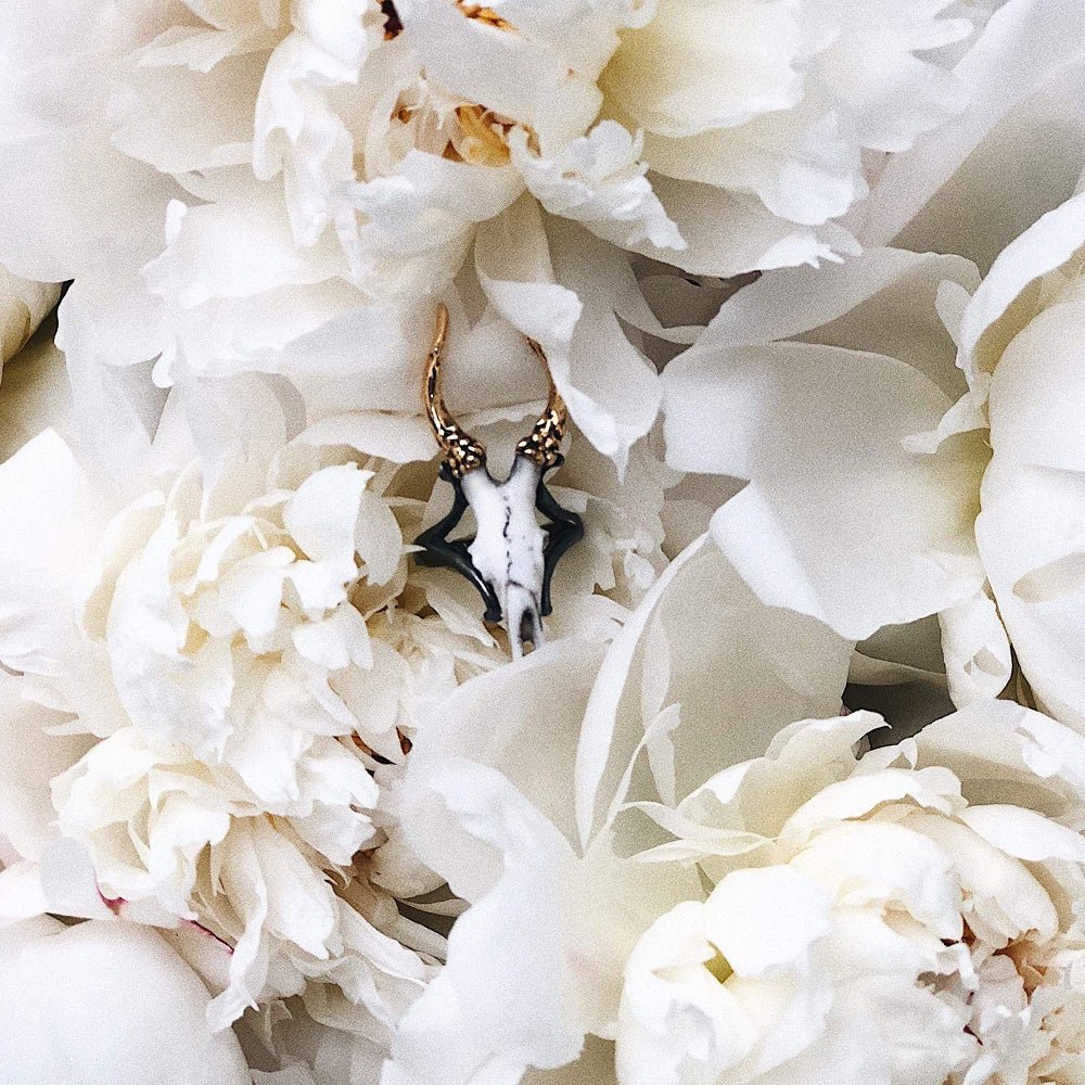 Doe ring placed among a peony flower petals, surrounded by other peonies