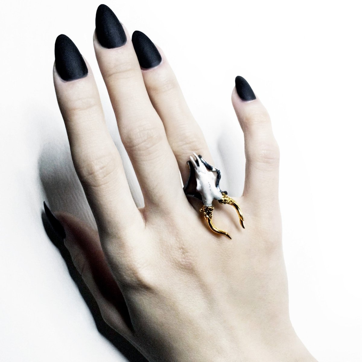 Doe ring on a woman's hand with long black nails