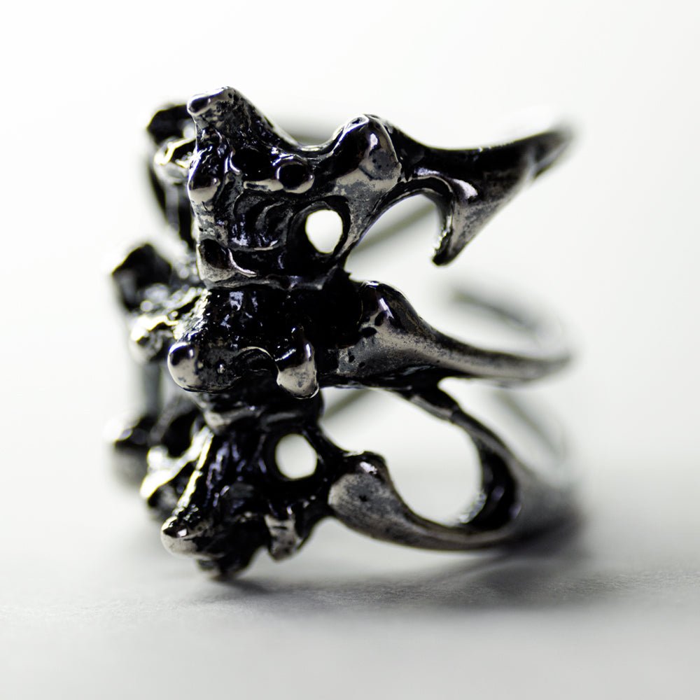 Gills Ribs ring - close-up of silver ring details like vertebrae and ribs on white surface