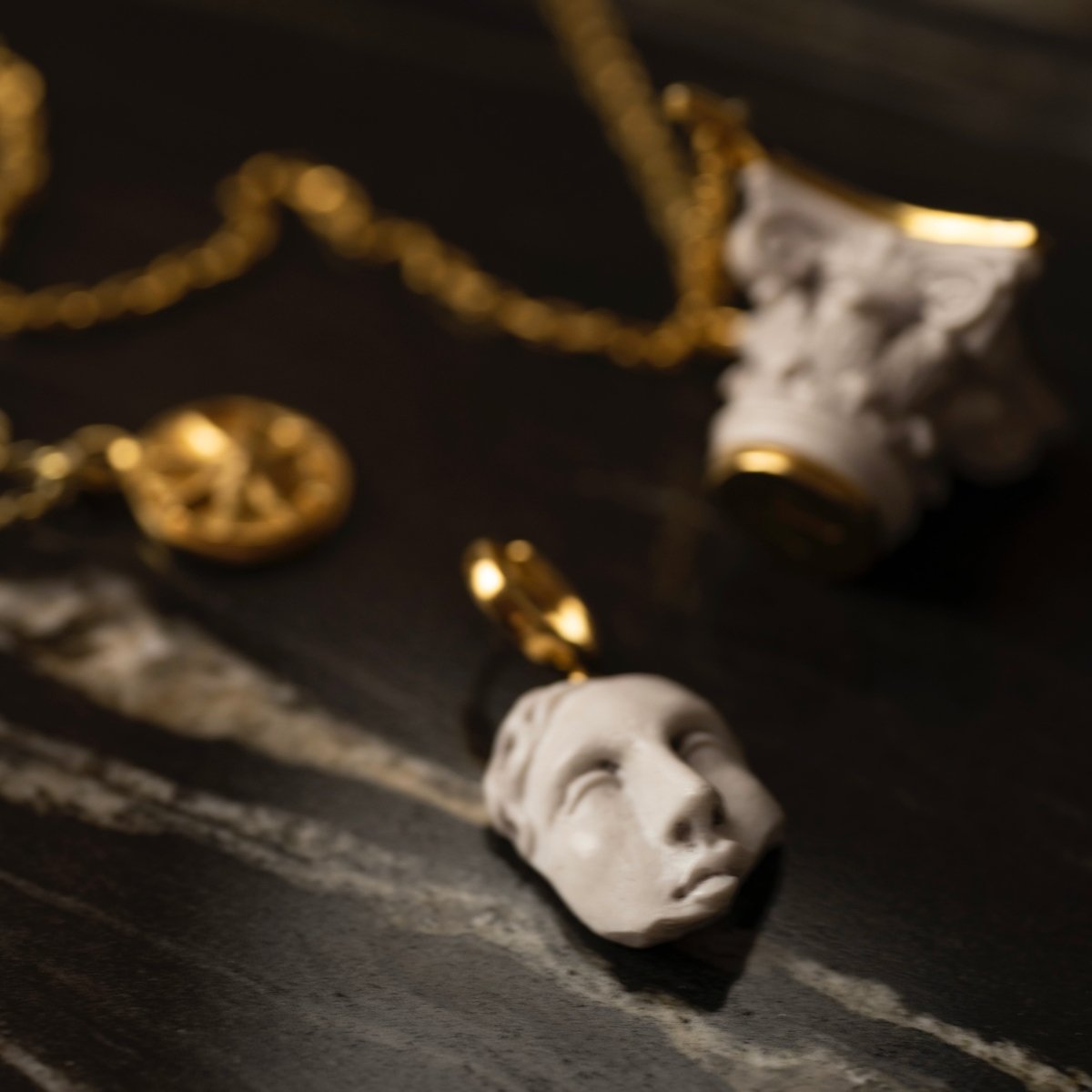Helen earring and Capital pendant by Macabre Gadgets on black marble surface