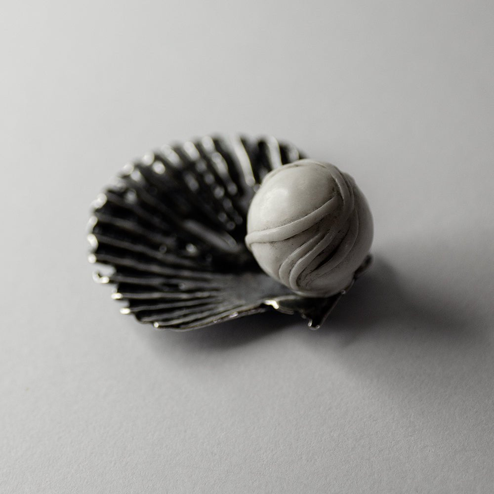 Large Seashell stud earring on a white surface, stud lock mechanism is shown