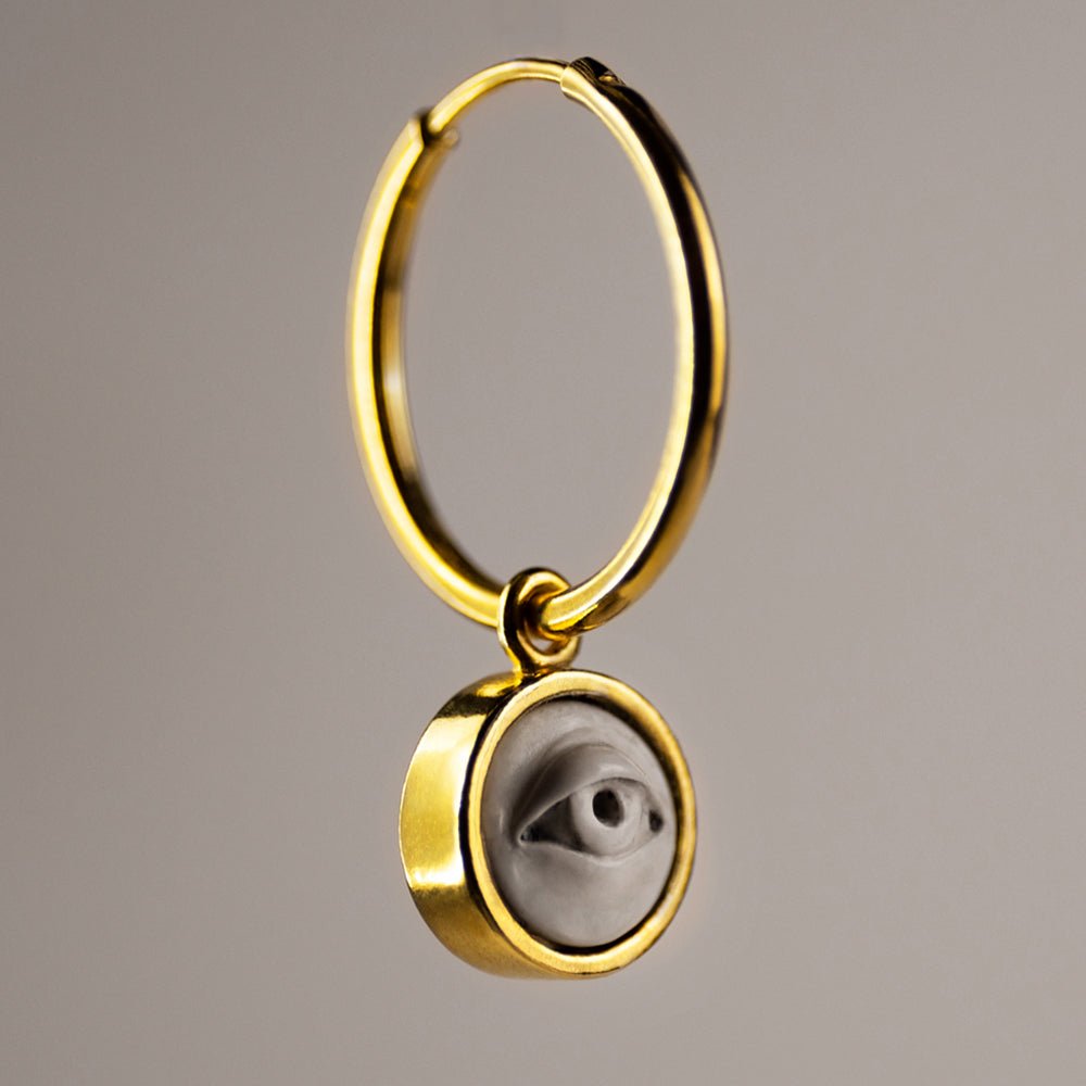 Oracle eye earring - hoop earring in gold-plated finish with an eye motif on neutral background