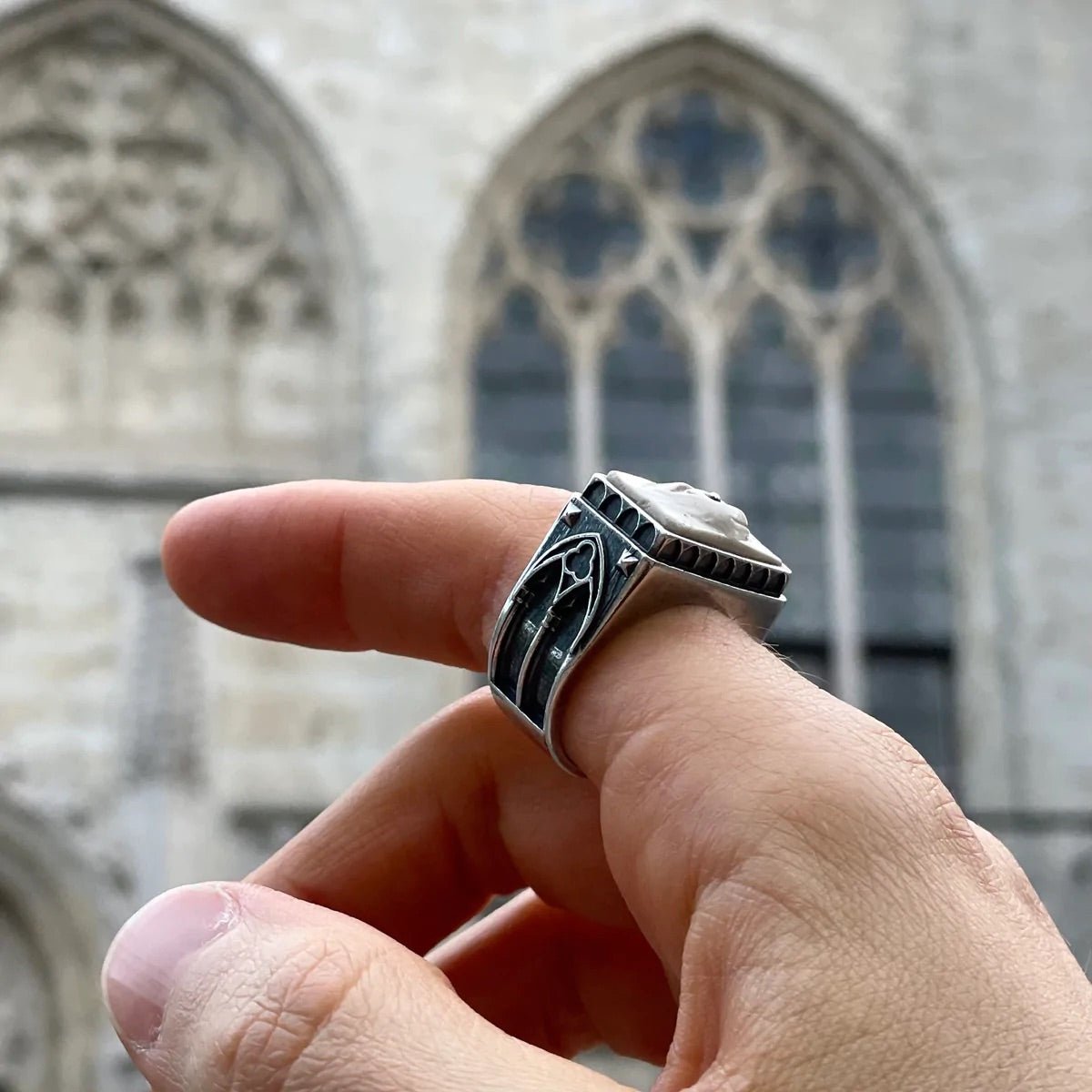 Oracle Gothic Eye Ring - on a model's hand in front of the gothic arched window, the ring positioned in a way that arches on a ring and on a window echo each other