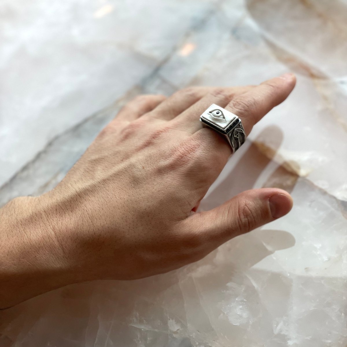 Oracle Gothic Eye Ring - white variant - on the model's hand, on a pink quartz surface