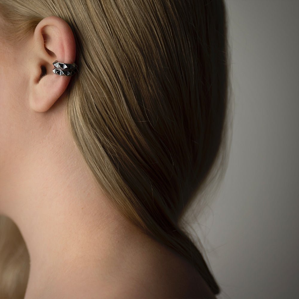 Female model wearing two Pyramids ear cuffs - dainty geometric silver jewelry