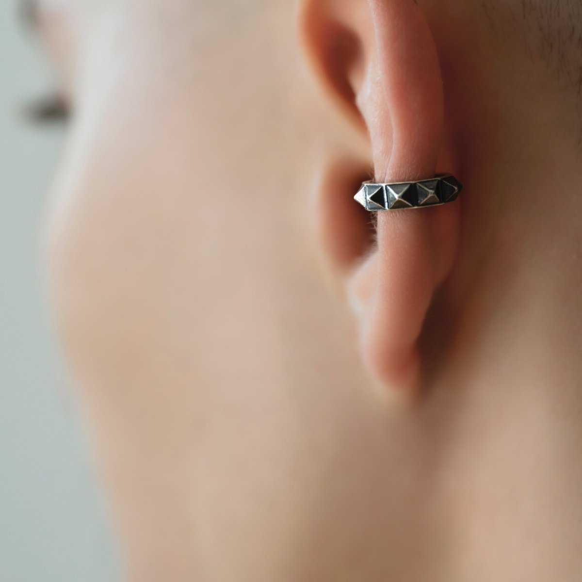 Model wearing Pyramids ear cuff close-up, handcrafted geometric no piercing jewelry lifestyle shot