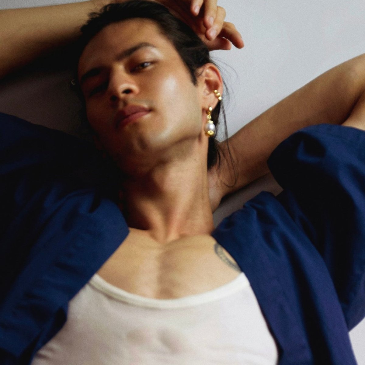 Male model wearing Pyramids ear cuff in gold-plated finish with other earrings by Macabre Gadgets - fashion editorial 