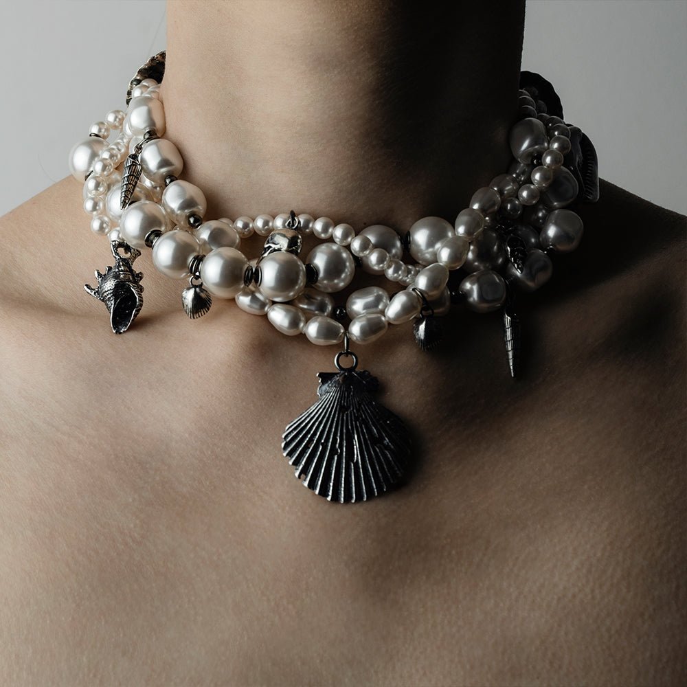Siren Pearl Necklace on a female model against white background with strings of different pearls and silver shells are clearly visible