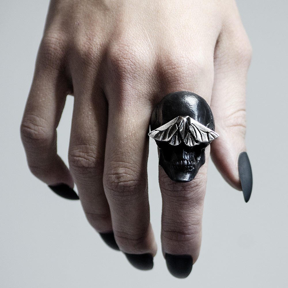 Skull & Moth ring - black variant - on a woman's hand with sharp black nails